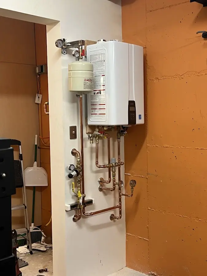 Plumbing technician inspecting water heater connections in Eaton